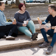 Auf dem Bild sieht man zwei Frauen und einen Mann, die sich unterhalten, zusammen lachen und ein Eis essen. Alle tragen Kompressionsstrümpfe in verschiedenen Ausführungen.